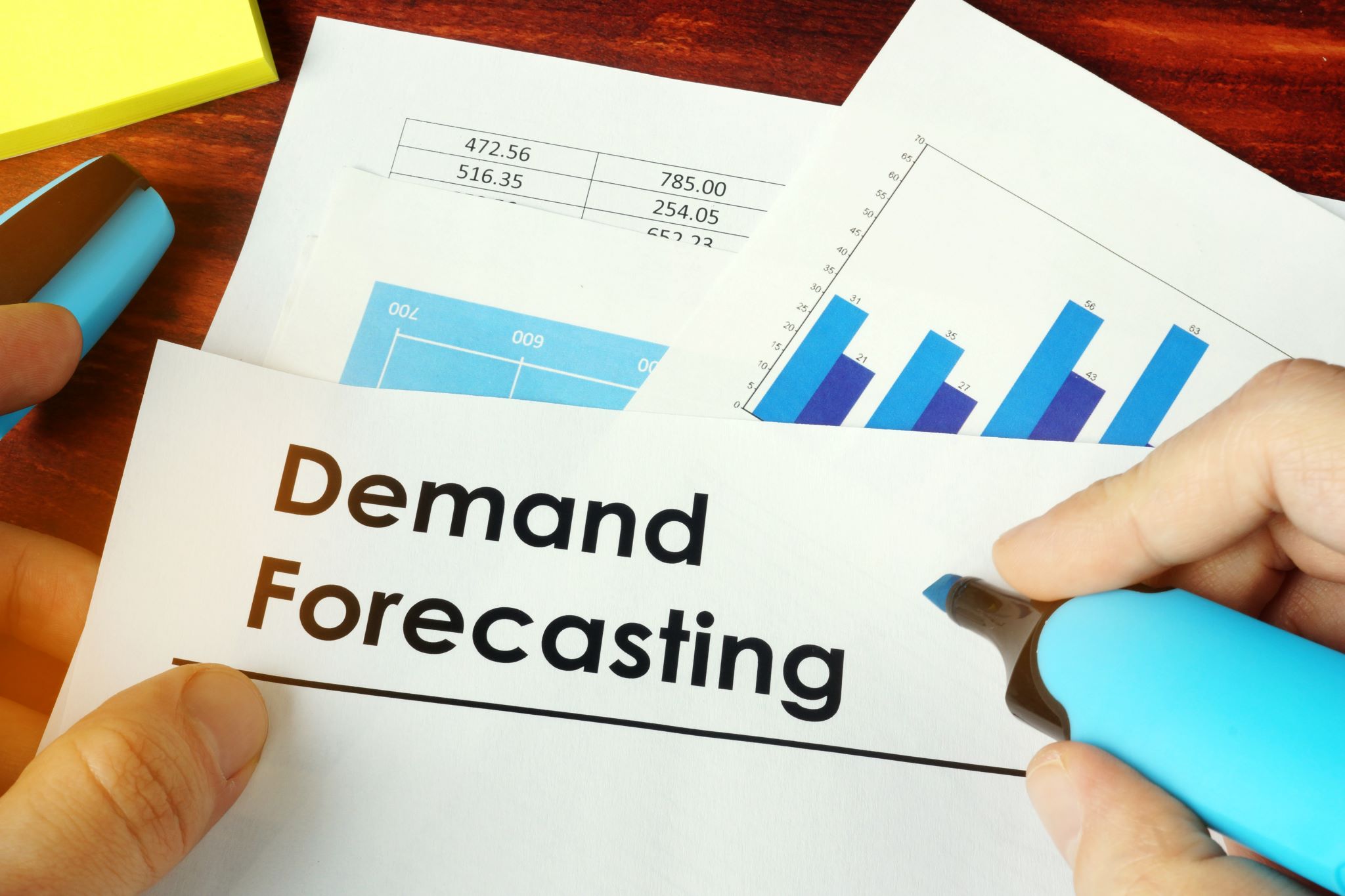 Man holding document titled Demand Forecasting