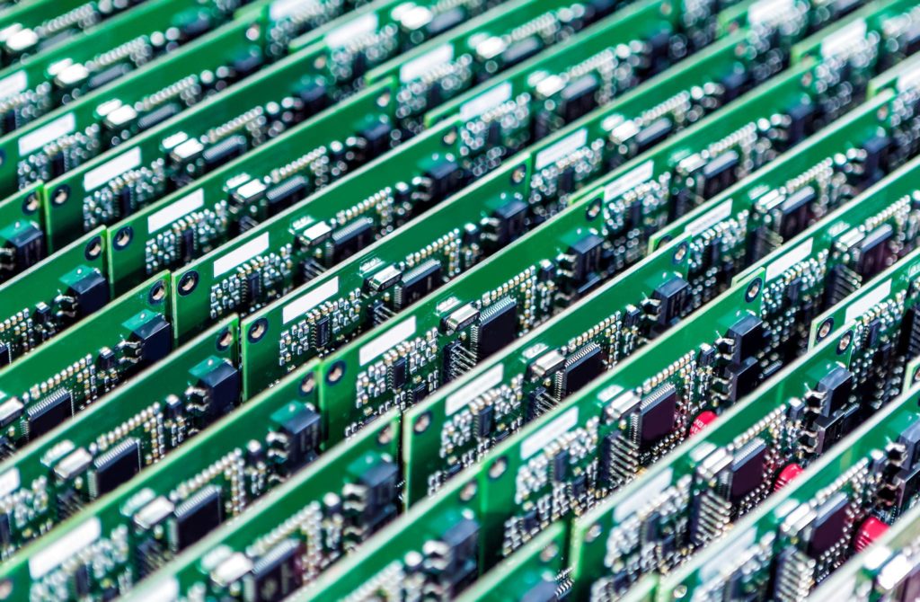 Numerous printed circuit boards with mounted and soldered componentry vertically aligned.