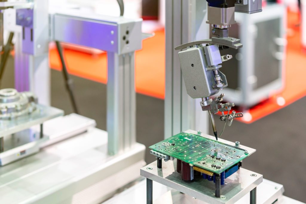 Modern automatic robot soldering during the manufacturing of a printed circuit board assembly (PCBA)