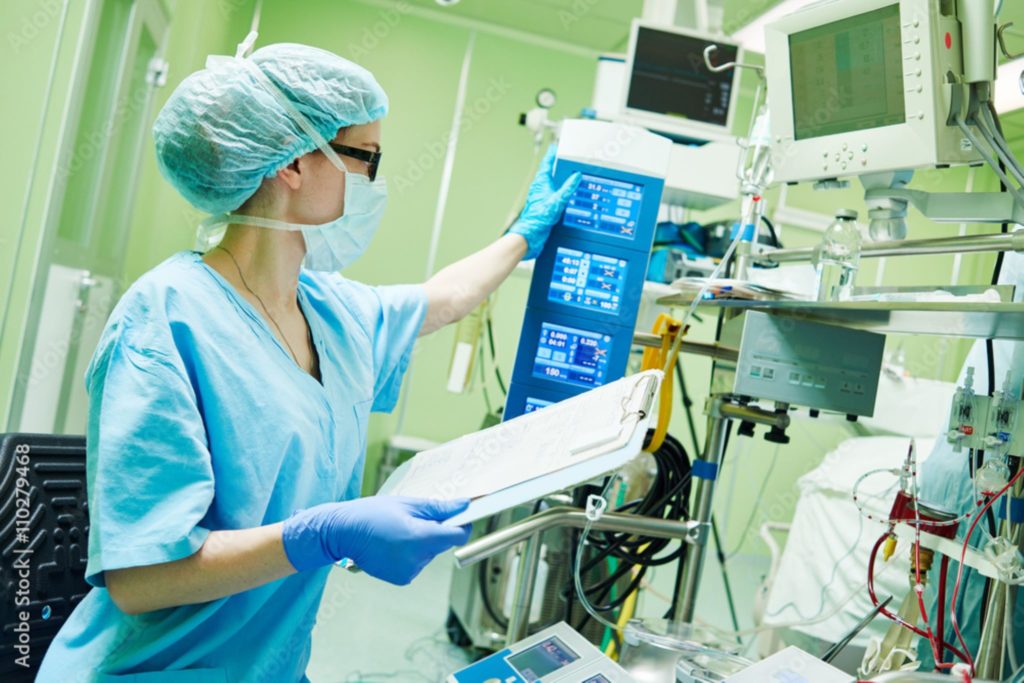Surgery assistant perfusionist operating a modern heart lung machine