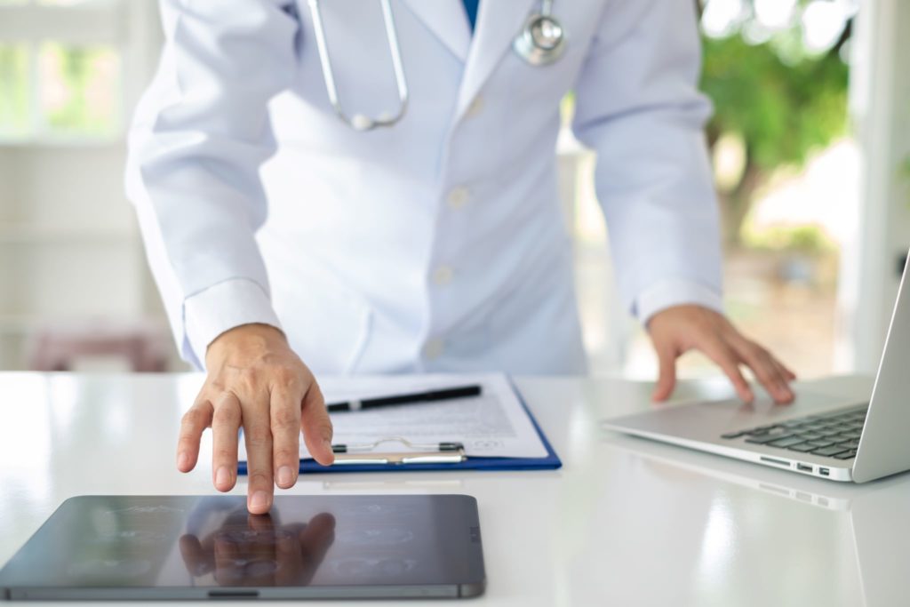 Doctor using digital tablet as a medical device