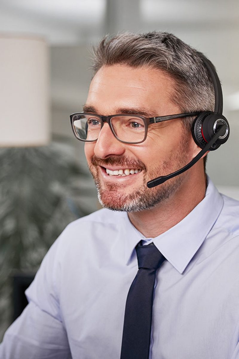 Shot of a call centre agent wearing a headset while working on his computer.